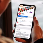 A young man going through QNET social media toolkit on his mobile