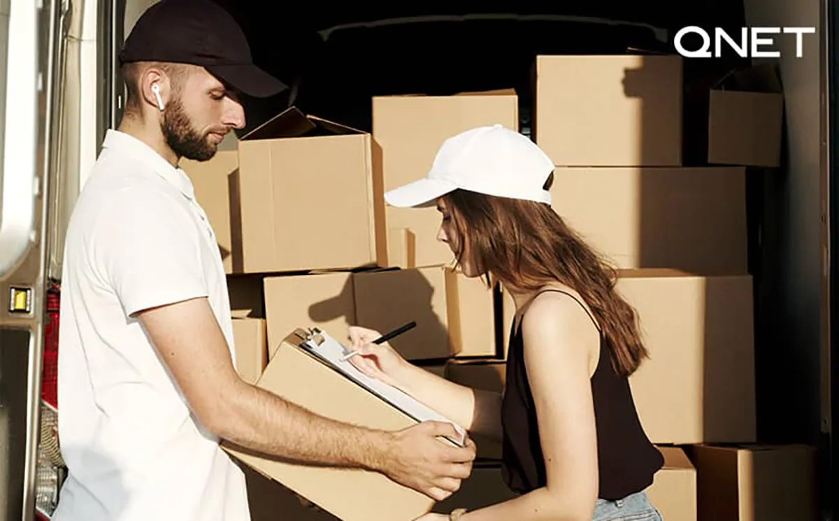 QNET staff moving boxes for charity