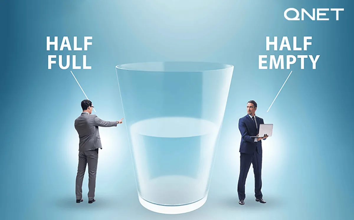 2 men looking at glass half full and half empty
