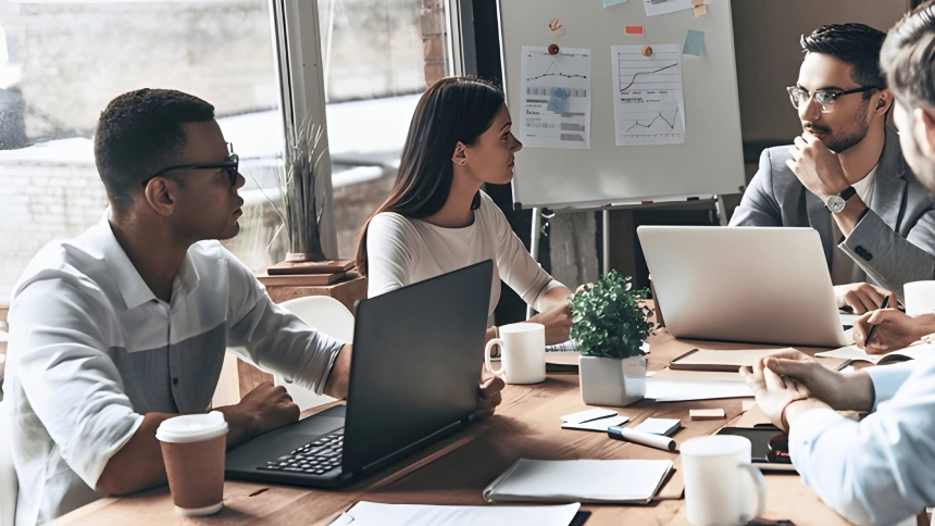 group of people in a meeting with laptops